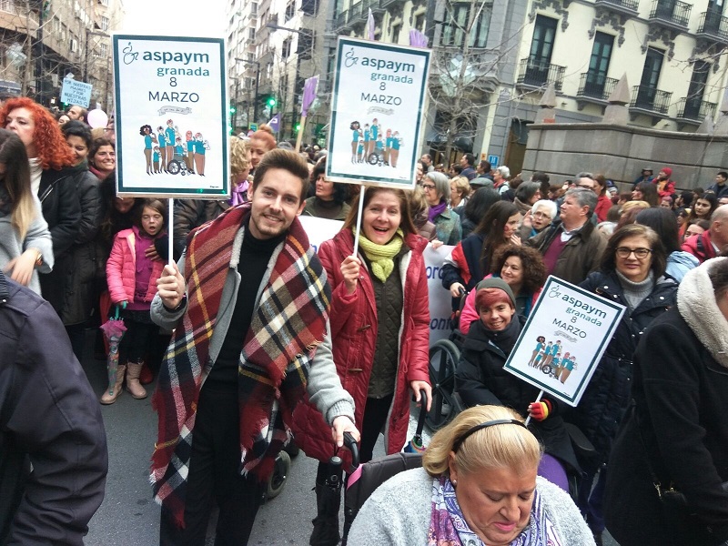 Grupo de mujeres participando en la manifestación. Entre ellas se puede ver a algunas que portan el cartel de ASPAYM Granada.