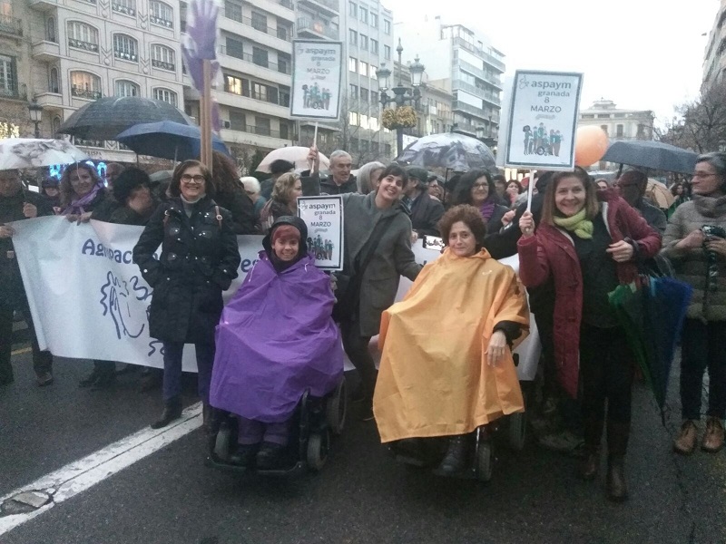 Grupo de mujeres participando en la manifestación. Entre ellas se puede ver a algunas que portan el cartel de ASPAYM Granada.